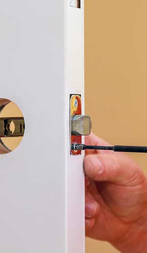 ADH - Installation locked interior door knobs, close-up wood worker hands install lock